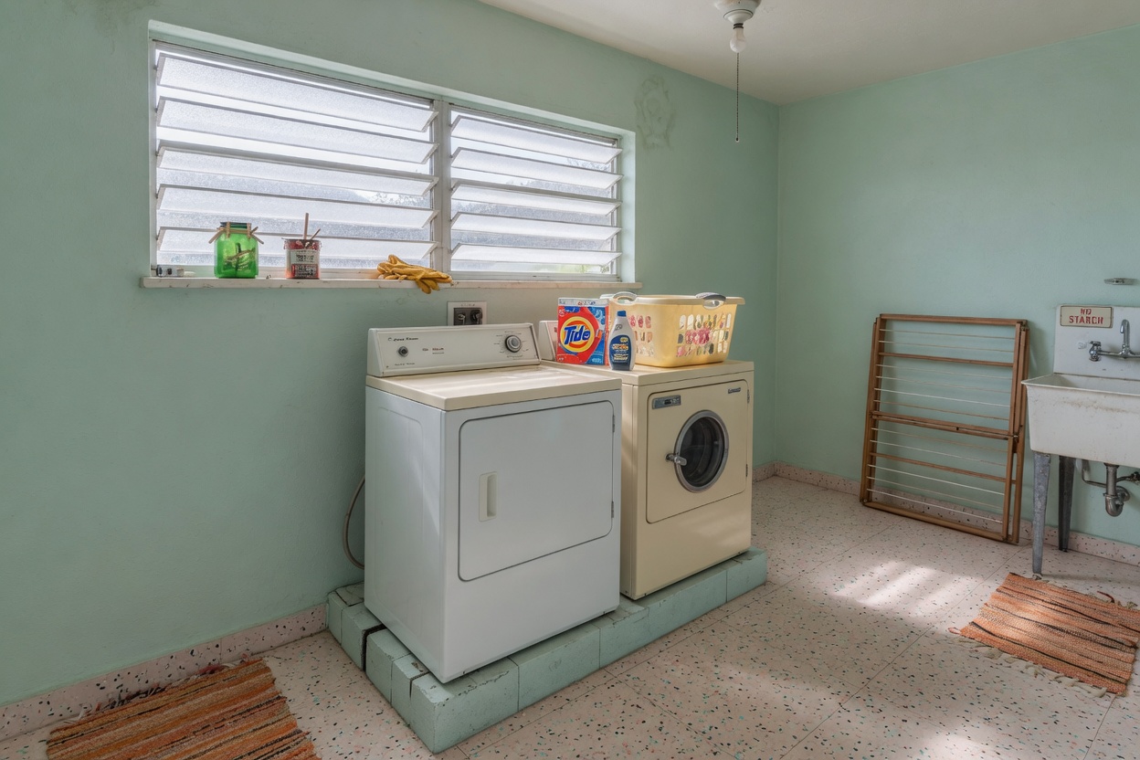Mid-century utility room with a washer and dryer under a high window